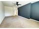 Large bedroom with neutral carpet, dark accent wall, and ceiling fan at 1570 Fox Grape Loop, Lutz, FL 33558