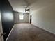 Bright bedroom features neutral carpet, a ceiling fan, black accent wall, and natural light at 1570 Fox Grape Loop, Lutz, FL 33558