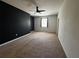 Large bedroom with neutral carpet, a ceiling fan and a black accent wall at 1570 Fox Grape Loop, Lutz, FL 33558