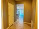 Hallway that leads into an open-concept kitchen and living area, with tiled flooring and neutral color tones at 1570 Fox Grape Loop, Lutz, FL 33558