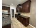 Modern kitchen with stainless steel appliances, granite countertops, and dark wood cabinets at 1570 Fox Grape Loop, Lutz, FL 33558