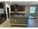 A spacious kitchen featuring a granite island, stainless steel appliances, and tile flooring at 1570 Fox Grape Loop, Lutz, FL 33558