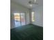 This bedroom boasts a large glass door and neutral decor to complement the light from outdoors at 5923 Sandstone Ave, Sarasota, FL 34243