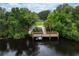 View of a wooden dock on the lake in a lush, green environment at 5923 Sandstone Ave, Sarasota, FL 34243