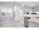 Bright kitchen with white cabinets, stainless steel appliances, and a view of the landscaped backyard at 5923 Sandstone Ave, Sarasota, FL 34243