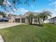 House exterior with a two-car garage and palm trees at 34434 Windknob Ct, Wesley Chapel, FL 33545