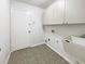 Laundry room with utility sink and ample cabinet space at 34434 Windknob Ct, Wesley Chapel, FL 33545