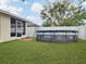 Backyard with an Intex above-ground pool, lush green lawn and white vinyl fence at 15427 Winter Breeze Ln, Wimauma, FL 33598