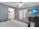 Bedroom showcasing a beach scene TV and a view of the bathroom at 15427 Winter Breeze Ln, Wimauma, FL 33598