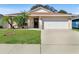 Charming one-story home with a well-manicured lawn and two-car garage at 15427 Winter Breeze Ln, Wimauma, FL 33598