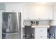 Bright kitchen featuring stainless steel appliances, a breakfast bar, and white cabinets at 15427 Winter Breeze Ln, Wimauma, FL 33598