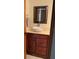 Bathroom features a vessel sink, a dark wood cabinet, a framed mirror and bright tile floor at 1322 Pelican Creek Xing # B, St Petersburg, FL 33707