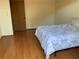 Bedroom with hardwood floors and a large bed with a floral comforter at 1322 Pelican Creek Xing # B, St Petersburg, FL 33707