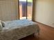 Bright bedroom features hardwood floors, a closet, and a sliding door to a patio at 1322 Pelican Creek Xing # B, St Petersburg, FL 33707