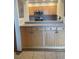 A well-lit kitchen features light wood cabinetry, stainless steel microwave, and a neutral countertop at 1322 Pelican Creek Xing # B, St Petersburg, FL 33707