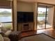 Bright living room featuring a waterfront view through large windows and sliding glass doors to a patio at 1322 Pelican Creek Xing # B, St Petersburg, FL 33707