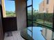 Enclosed patio area featuring a glass-top table, screened windows, and a view of lush greenery at 1322 Pelican Creek Xing # B, St Petersburg, FL 33707