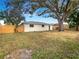 Spacious backyard with large shade tree and wooden fence at 4642 Spahn St, Sarasota, FL 34232