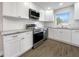 Modern kitchen with white cabinets, granite countertops, and stainless steel appliances at 4642 Spahn St, Sarasota, FL 34232