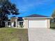 Charming single-story home featuring a well-manicured lawn, brick paved driveway, and attached two-car garage at 37 Warrington Blvd, Port Charlotte, FL 33954