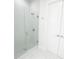 Glass enclosed shower with modern fixtures, next to a sleek, white door at 37 Warrington Blvd, Port Charlotte, FL 33954