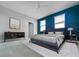 Modern bedroom with blue accent wall, sleek furniture, and ample natural light at 7480 Aguila Dr, Sarasota, FL 34240