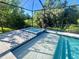 Sparkling in-ground pool and spa with blue tile accents in a screened enclosure at 7480 Aguila Dr, Sarasota, FL 34240