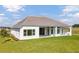 Rear exterior showing covered porch and manicured lawn at 14036 Prairie Hill Rd, Dade City, FL 33525