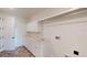 Bright laundry room features white cabinets, herringbone floors, and sleek quartz countertops at 14036 Prairie Hill Rd, Dade City, FL 33525
