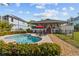 Beautiful backyard featuring a sparkling pool, patio with lounge chairs, and well-maintained landscaping at 505 Sally Lee Dr, Ellenton, FL 34222