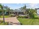 Inviting home with a spacious front porch, brick driveway, and lush landscaping, offering a warm welcome at 505 Sally Lee Dr, Ellenton, FL 34222