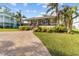 Charming single-story home with a covered front porch, brick driveway, and lush landscaping at 505 Sally Lee Dr, Ellenton, FL 34222