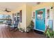 Charming front porch featuring a turquoise front door and rocking chairs, providing a welcoming entrance at 505 Sally Lee Dr, Ellenton, FL 34222
