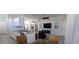 Bright kitchen area offering white cabinets, granite counters, stainless appliances, and a view to the living area at 1287 Lakeside Woods Dr, Venice, FL 34285