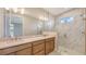 This primary bath boasts double sinks, granite counters, and a glass-enclosed shower with marble tile at 14370 Hammock Oak St, Parrish, FL 34219