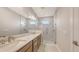 This primary bath features double sinks, granite counters, and a glass-enclosed shower with marble at 14370 Hammock Oak St, Parrish, FL 34219