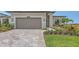 Beautiful single Gathering home with a two-car garage, brick driveway, and manicured landscaping at 14370 Hammock Oak St, Parrish, FL 34219