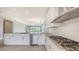 Modern kitchen featuring white cabinetry, stainless steel appliances, granite countertops, and view of the backyard at 14370 Hammock Oak St, Parrish, FL 34219