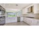 Open kitchen with stainless appliances, white cabinets, granite countertops, tile backsplash, and tile floors at 14370 Hammock Oak St, Parrish, FL 34219