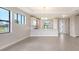 Open-concept living room featuring a kitchen with white cabinets and bright recessed lighting at 14370 Hammock Oak St, Parrish, FL 34219