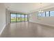 Bright living room featuring large windows, neutral tile flooring, and modern chandelier at 14370 Hammock Oak St, Parrish, FL 34219