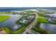 Gorgeous aerial view of the community amenities, including the pool, tennis court, landscaping, and clubhouse by the lake at 4621 Mondrian Ct, Sarasota, FL 34240