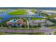 Aerial view of the community pool, playground, parking, clubhouse, and surrounding lake at 4621 Mondrian Ct, Sarasota, FL 34240