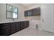 Laundry room with dark cabinets, a sink, a quartz countertop, and a door to the garage at 4621 Mondrian Ct, Sarasota, FL 34240