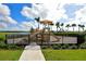 Community playground with slides and climbing structures behind a black metal fence at 4621 Mondrian Ct, Sarasota, FL 34240