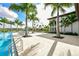 Community pool with palm trees, lounge chairs, and white tile flooring at 4621 Mondrian Ct, Sarasota, FL 34240