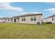 Sprawling backyard featuring neutral home, covered patio, and lush green lawn at 466 Sun Chaser Dr, Nokomis, FL 34275