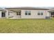 View of backyard with healthy lawn, exterior of house, and covered porch area at 466 Sun Chaser Dr, Nokomis, FL 34275