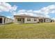 A spacious green backyard of a beige single Gathering home with covered patio at 466 Sun Chaser Dr, Nokomis, FL 34275