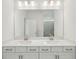 Bathroom featuring double sinks, white cabinets and a large mirror at 466 Sun Chaser Dr, Nokomis, FL 34275